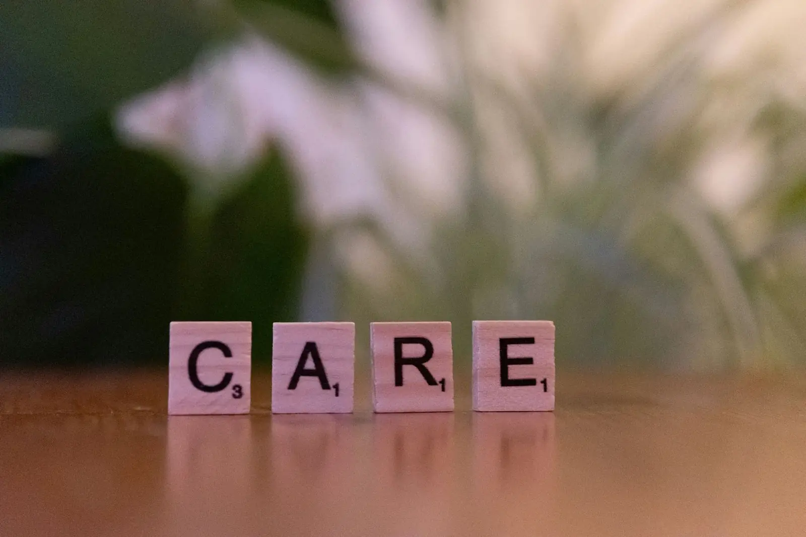 Wooden letter tiles spelling the word care