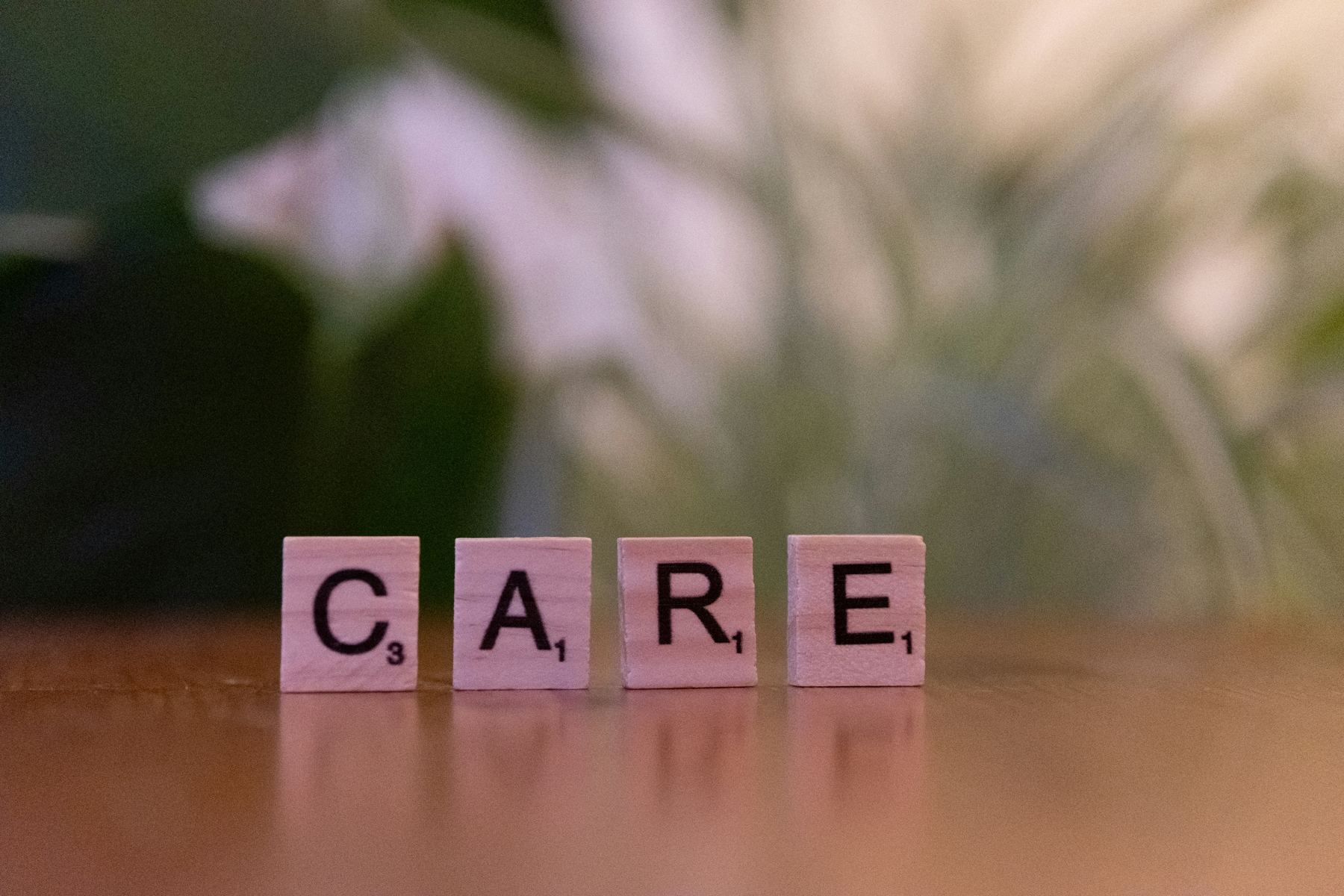 Wooden letter tiles spelling the word care