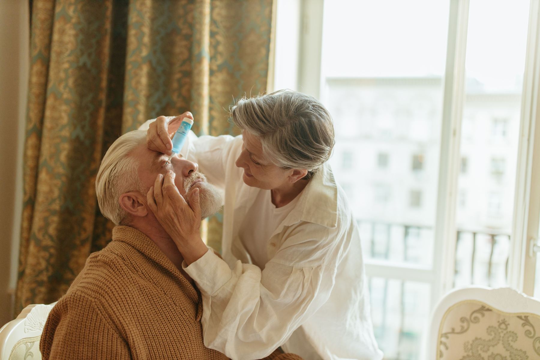 A caregiver helping a senior man at home